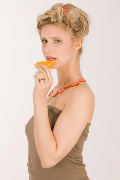 Attractive young blond woman with strawberry-kiwi-chain — Stock Photo, Image