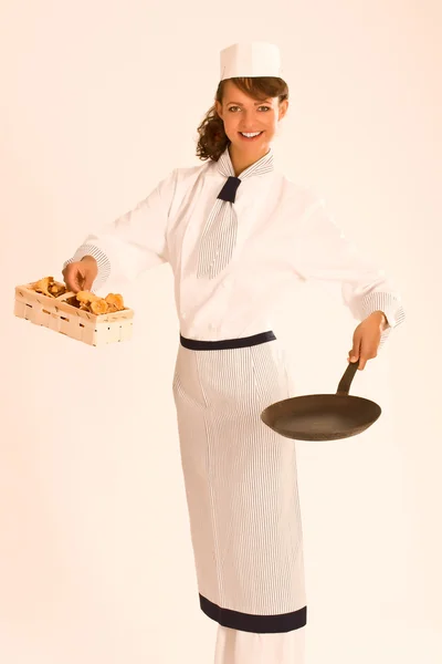 Female chef with chanterelle mushrooms, pan and apron — Stock Photo, Image