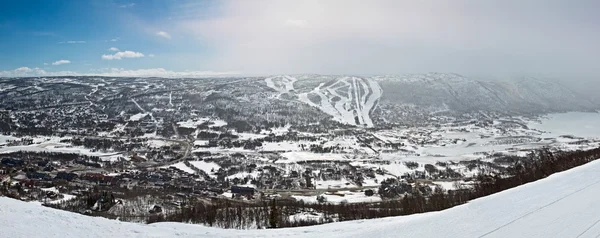 Panoramautsikt over en liten by i dalen med vinterfjell – stockfoto