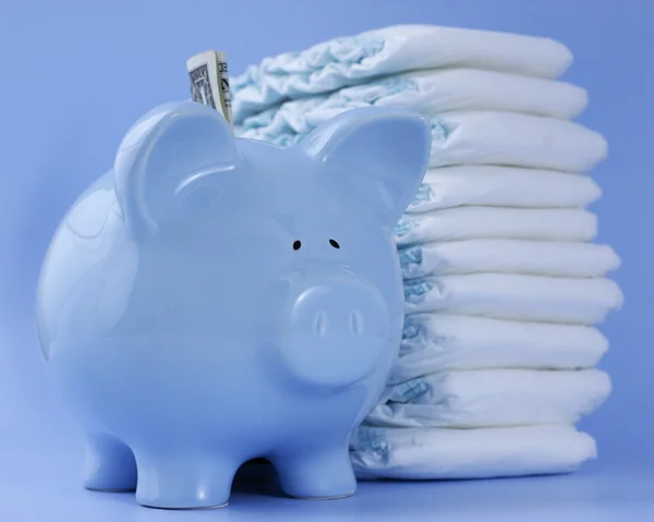 Baby blue piggy bank with diapers on blue Stock Photo