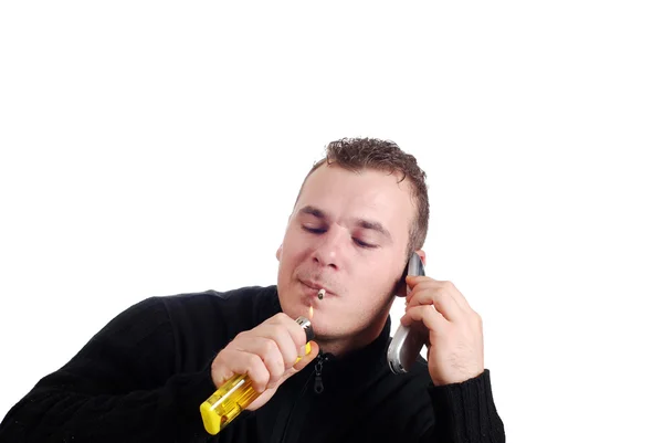 Молодой человек говорит по мобильному и курит. — стоковое фото