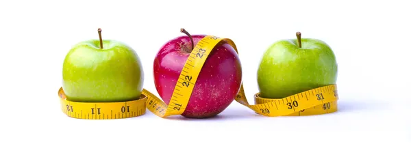 Tres manzanas y cinta métrica Imagen de stock