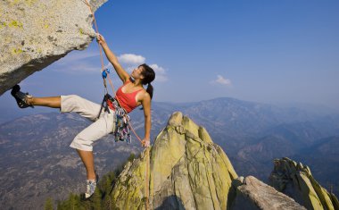 Female rock climber rappelling. clipart