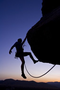 Rock climber dangling. clipart