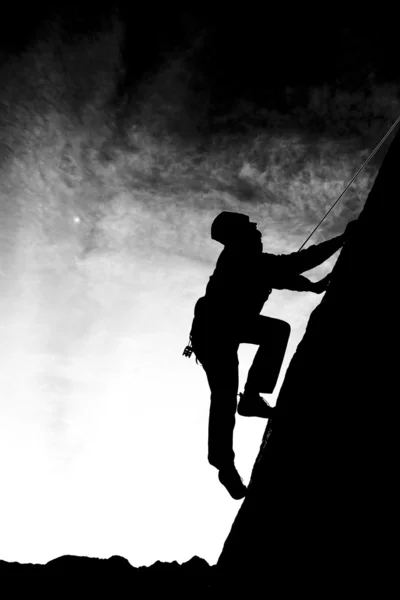 Bergsteiger klammert sich an einen Überhang. — Stockfoto