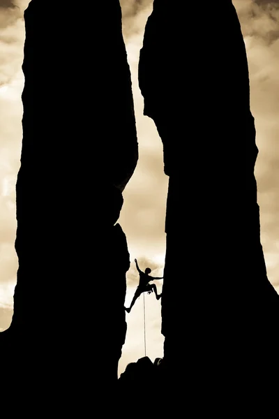 Rock klimmer bereiken over een kloof. — Stockfoto