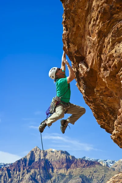 Hombre escalador alcanzando la cumbre . — Foto de Stock