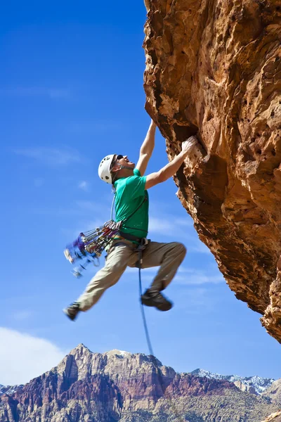 Hombre escalador alcanzando la cumbre . — Foto de Stock