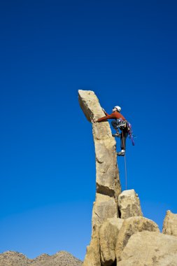 Rock climber nearing the summit. clipart