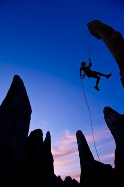 Rock climber rappelling. clipart