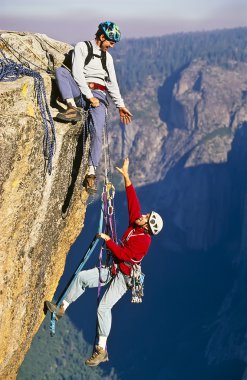 Rock climbing team reaching the summit. clipart