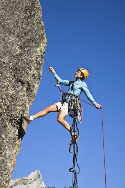 Rock climber rappelling. clipart