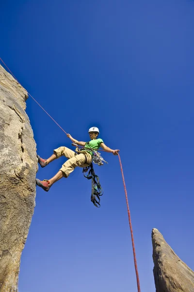 Rock climber rappelling. Stock Photo