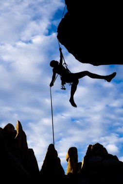 Climber dangling from a rope. clipart