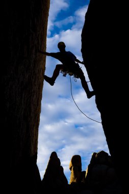 Climber clinging to a steep rock. clipart