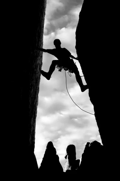 Bergsteiger klammert sich an einen steilen Felsen. — Stockfoto