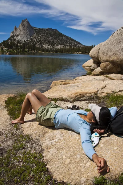 Female hiker relaxing near a lake. — Stock Photo, Image