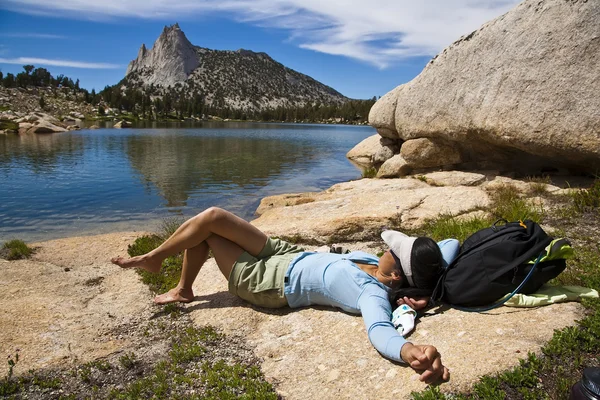 Vrouwelijke wandelaar ontspannen in de buurt van een meer. — Stockfoto