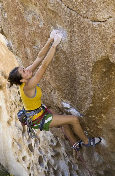 Vrouwelijke klimmer klampt zich vast aan een klif. — Stockfoto