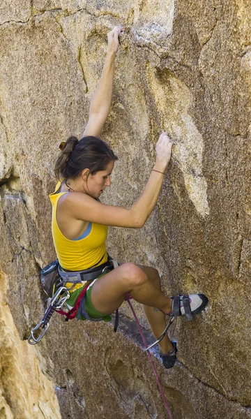 Bergsteigerin klammert sich an Klippe. — Stockfoto