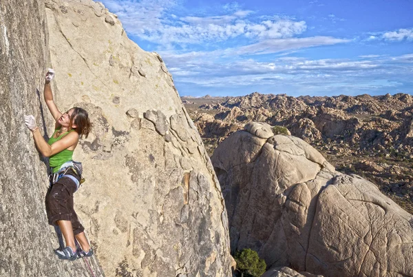Mujer escaladora aferrada a un acantilado . — Foto de Stock