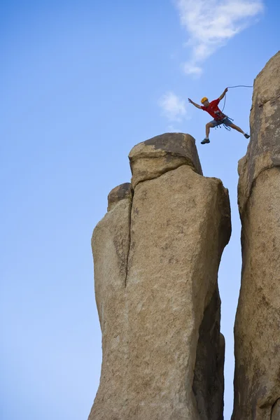 Rock climber hoppning för toppmötet. — Stockfoto