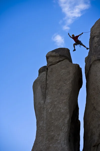 Rock climber hoppning för toppmötet. — Stockfoto