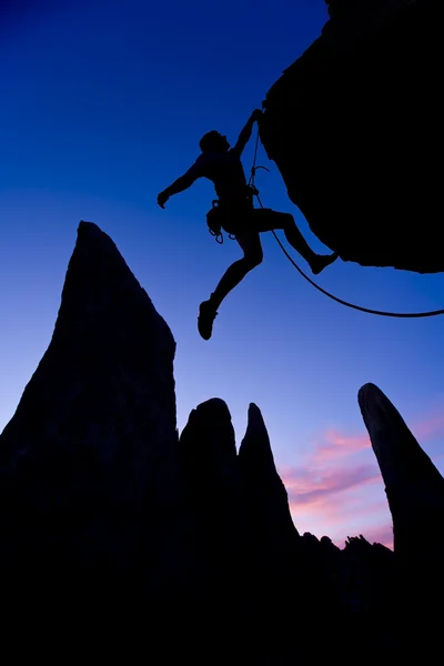 Rock climber dangling by one arm. — Stock Photo, Image