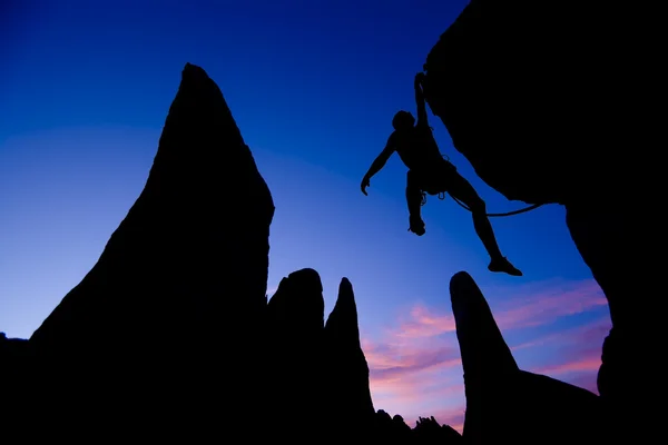 Rock climber dangling by one arm. — Stock Photo, Image