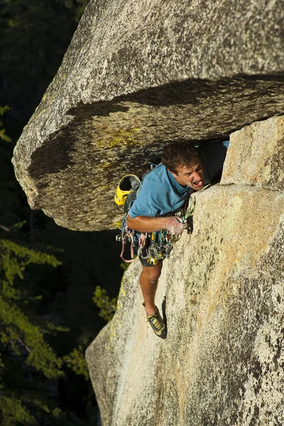 Rock klättrare struggelling upp en spricka. — Stockfoto