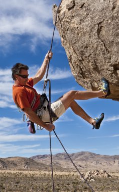 Rock climber rappelling. clipart