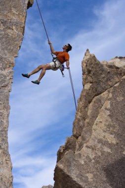 Rock climber rappelling. clipart