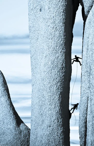 Bergsteigerteam kämpft sich eine steile Klippe hinauf. — Stockfoto