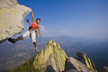 Female rock climber rappelling. clipart