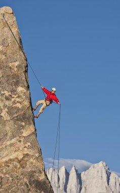 Rock climber rappelling. clipart