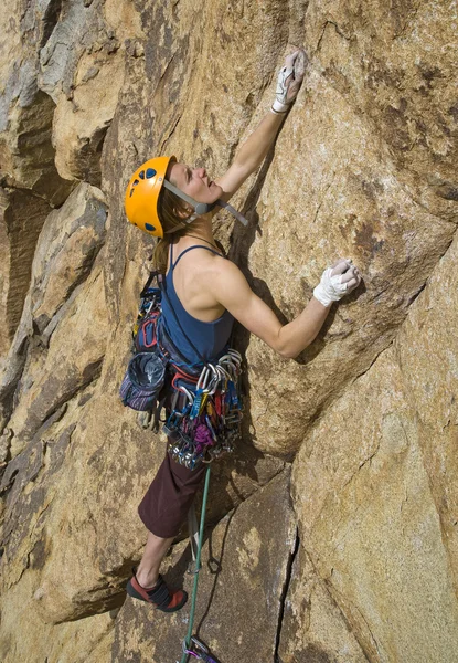 Female rock climber clinging to a crack. — Stockfoto