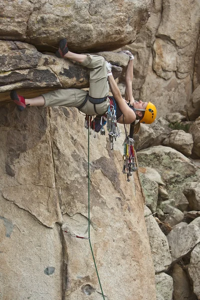 Escalador de rocha agarrado a um penhasco íngreme . — Fotografia de Stock