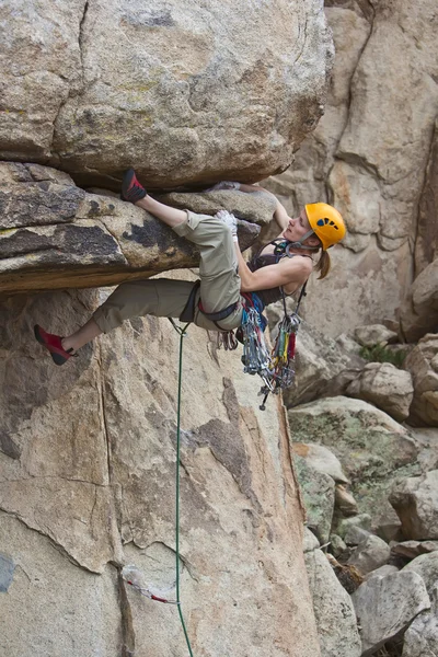 Rock klimmer klampt zich vast aan een steile klif. — Stockfoto