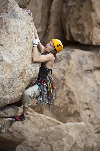 Bergsteiger klammert sich an steile Klippe. — Stockfoto