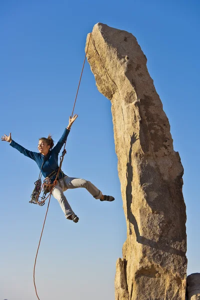 Vrouwelijke rock klimmer abseilen. — Stockfoto