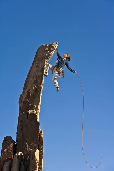 Kobieta wspinacz, osiągając szczyt. — Zdjęcie stockowe