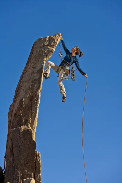 Kobieta wspinacz, osiągając szczyt. — Zdjęcie stockowe
