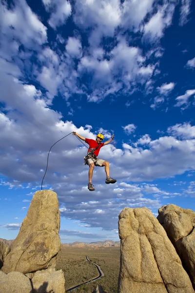 Bergsteiger springt über Lücke. — Stockfoto