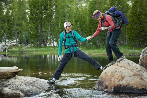 Hikers crossing a stream. — Stock Photo, Image