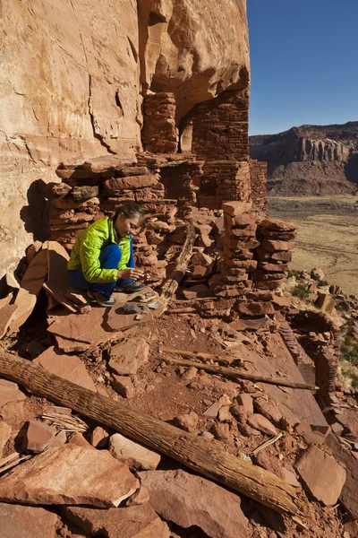Caminhante explora um antigo Anasazi penhasco-habitação . — Fotografia de Stock
