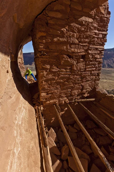 Hiker explores an ancient Anasazi cliff-dwelling. — Stock Photo, Image