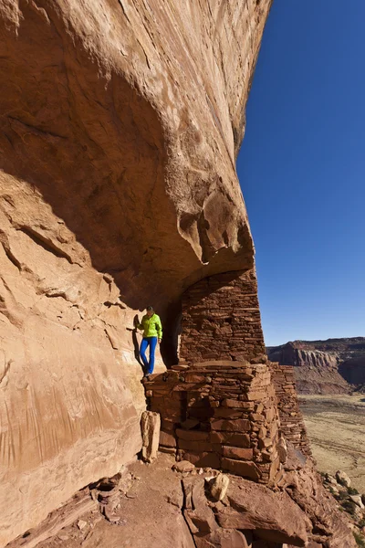 Randonneur explore une ancienne falaise Anasazi-habitation . — Photo