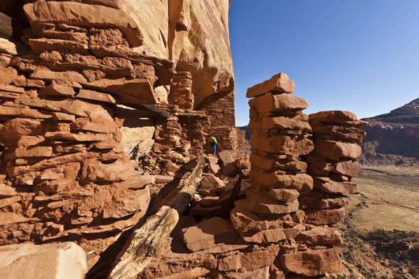 Hiker utforskar en gamla anasazi cliff-bostad. — Stockfoto