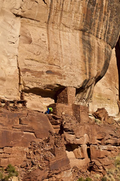 Caminhante explora um antigo Anasazi penhasco-habitação . — Fotografia de Stock