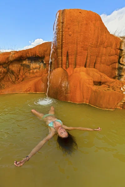 Ung kvinna avkopplande i en hotspring pool. — Stockfoto